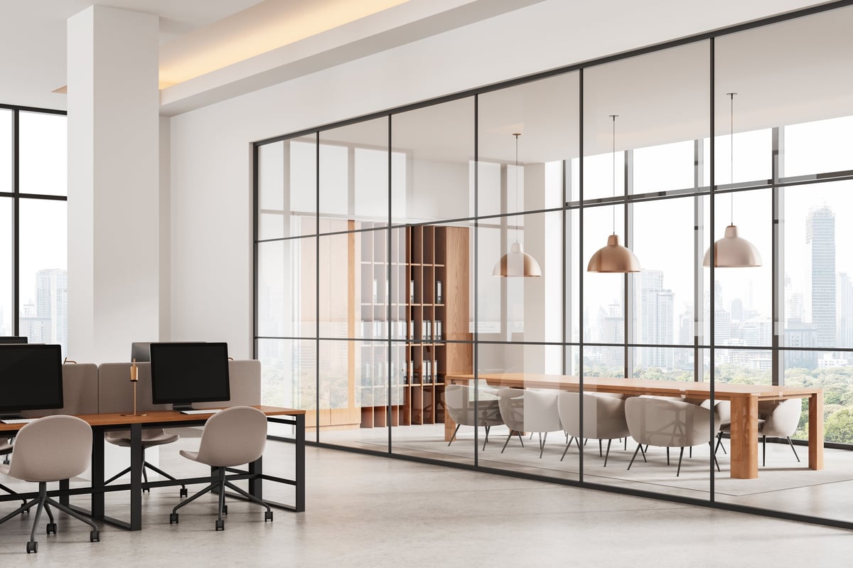 Contemporary office interior with shared desks and a glass-enclosed meeting room, modern design elements, daylight cityscape background, concept of workspace. 3D Rendering